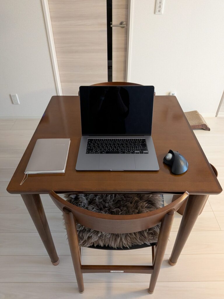 ダイニングテーブルの上にMacbook   Airを置いた作業風景