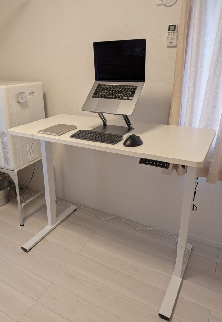昇降デスクにPCスタンドとワイヤレスキーボードを設置した作業環境の俯瞰