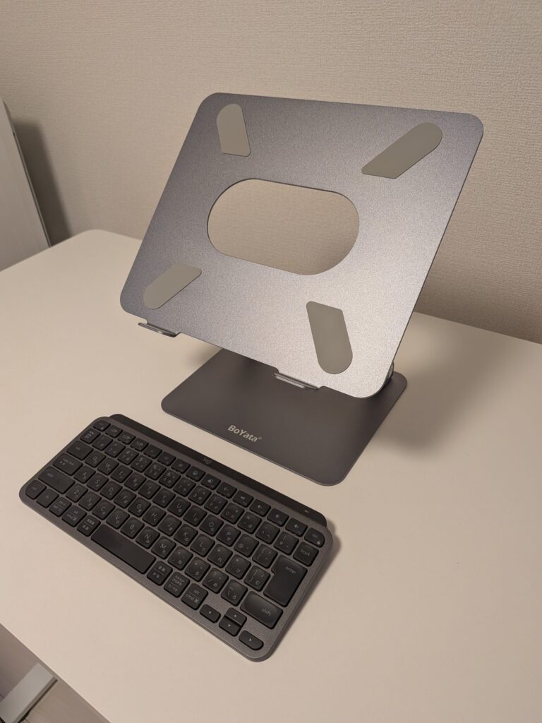 BoYataのノートPCスタンドとlogicoolのワイヤレスキーボードをデスクの上に載せて高さ調整している様子